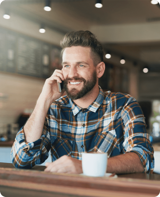 A smiling man with phone call in check shirt